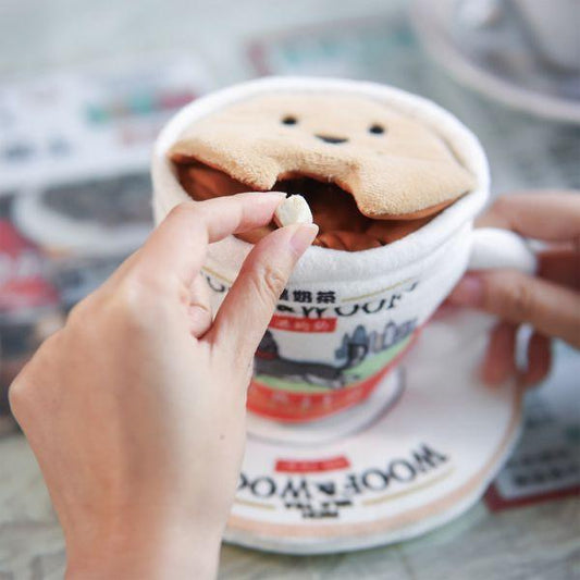 Hands placing a treat inside the Woof² Hong Kong Milk Tea 2-in-1 Nose-work Dog Toy, showing how to hide snacks under the plush lid for interactive play.