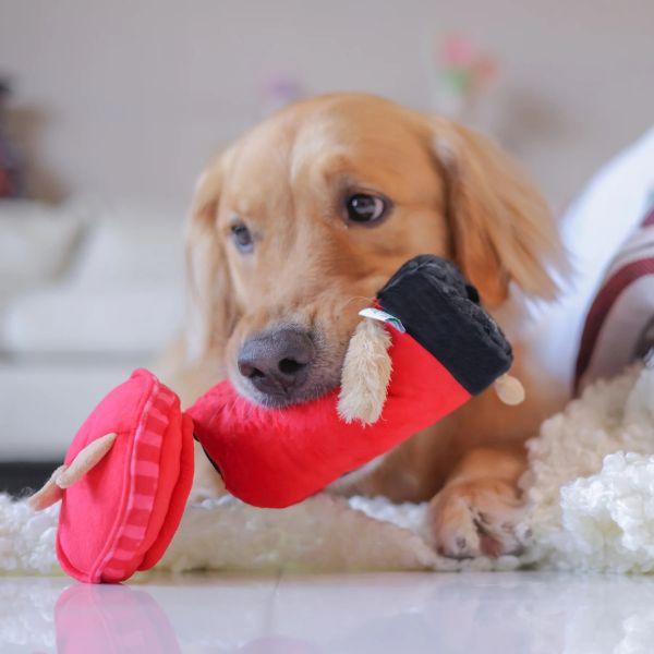 Dog is chewing on a Woof² British Postbox Treat-Dispensing Dog Toy