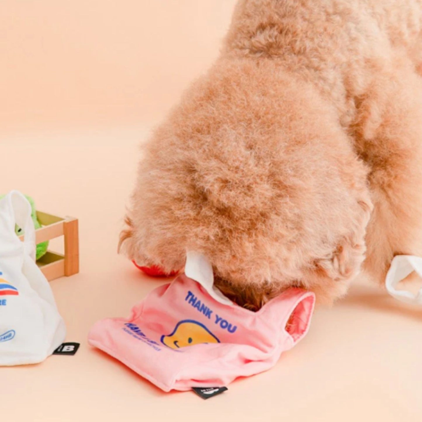 Small dog playing with the Pink BITE ME Crinkle Shopping Bag dog toy.