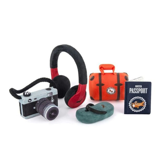P.L.A.Y. Globetrotter Collection plush dog toys including suitcase, passport, headphones, and camera for travel-loving pups