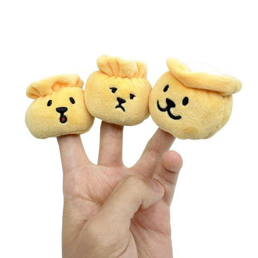 Hand holding the three plush siu mai pieces from the Woof² Siu Mai Brothers Dog Toy on fingertips, showing cute character faces.